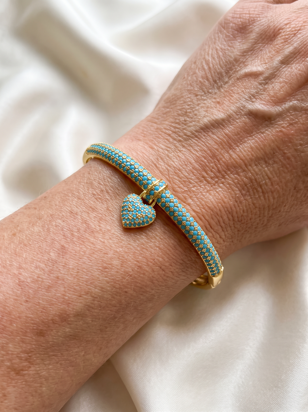 Gold-tone bangle with heart charm and blue cubic zirconia for women